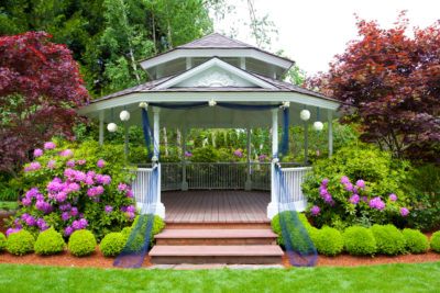 Gazebo among the flowers of a garden helps brand a wedding "romantic." 